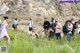 A group of people standing in a grassy field.