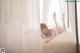 A woman laying on a bed in a white lingerie.