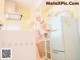 A woman in a bunny costume standing in a kitchen.