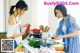 Two women in a kitchen preparing food together. 