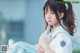 A young woman in a school uniform holding a bottle of water.