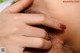 A close up of a woman's hand touching her hairy pussy.