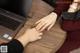 A woman sitting at a table with a laptop and a ring on her finger.