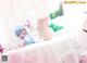 A woman laying on top of a bed with a stuffed animal.