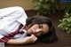 A woman in a white shirt and red tie laying on the ground.